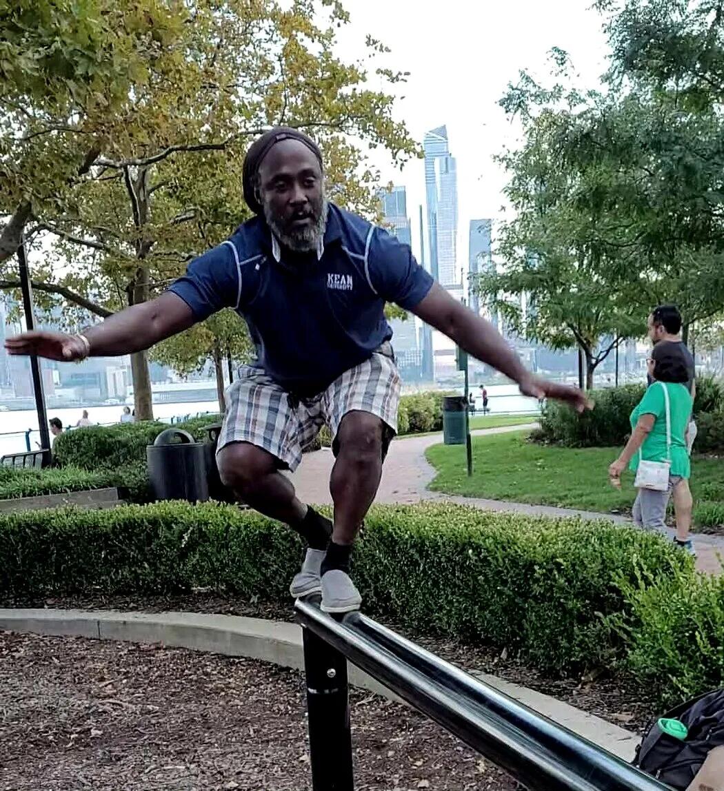 Irvin Charleston balancing on a rail beside the Hudson County waterfront